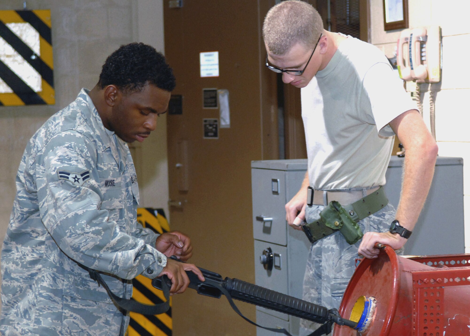 Airman 1st Class Kyle Saringer, 49th Logistics Readiness Squadron, looks on as Airman 1st Class Darnel Moore, also from the 49 LRS, clears his weapon, September 15. Airman Moore recently returned home from a six month deployment to Kirkuk Air Force Base, Iraq. While deployed Airman Moore worked as a traffic management specialist. (U.S. Air Force photo/Airman 1st Class Veronica Salgado)