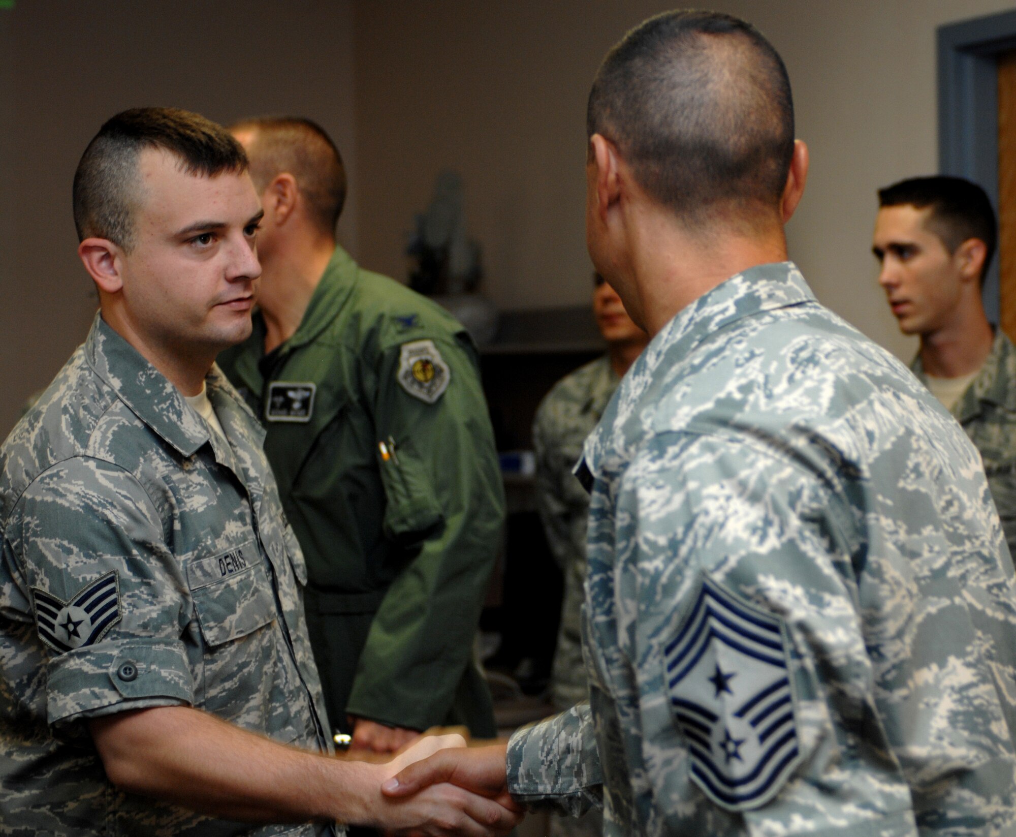 Chief Master Sgt. Jeffrey Cui, 49th Fighter Wing command chief, shakes the hand of Staff Sgt. Marcus Denis, 49th Logistics Readiness Squadron, at Holloman Air Force Base, N.M., September 23. Sergeant Denis was one of 12 Airmen who just returned from an eight-month deployment to Kuwait.  (U.S. Air Force photo/Airman Sondra M. Escutia)
