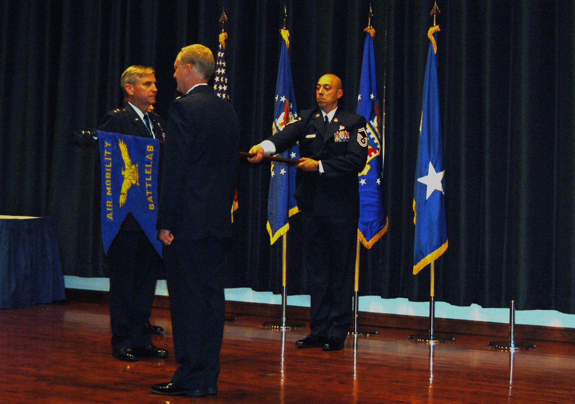 Senior Master Sgt. Dominic Perino, Air Mobility Battlelab superintendent, dips the flag of the battlelab one last time as it is prepared to be rolled and cased Sept. 24, 2008, as part of a deactivation ceremony of the battlelab in the U.S. Air Force Expeditionary Center's Grace Peterson Hall.  The Air Mobility Battlelab deactivated after 10 years.  (U.S. Air Force Photo/Tech. Sgt. Scott T. Sturkol)