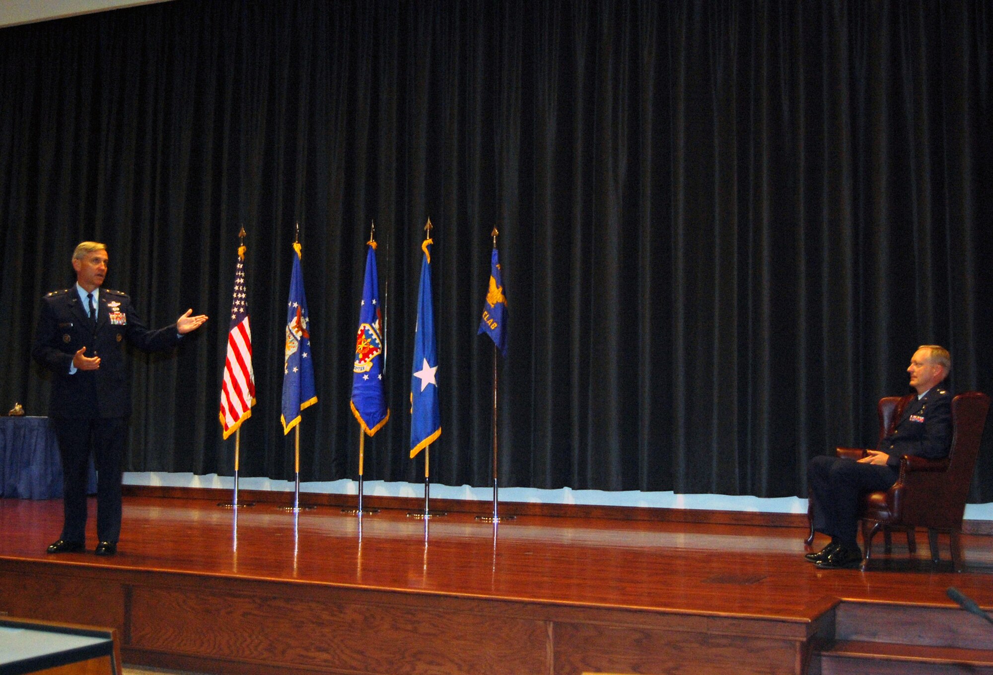 Maj. Gen. Kip Self, U.S. Air Force Expeditionary Center commander and presiding official for the Air Mobility Battlelab deactivation ceremony Sept. 24, 2008, provides words about the battlelab and its last commander, Lt. Col. Jeffrey Lathrop (seated), during the ceremony in the center's Grace Peterson Hall.  (U.S. Air Force Photo/Tech. Sgt. Scott T. Sturkol)