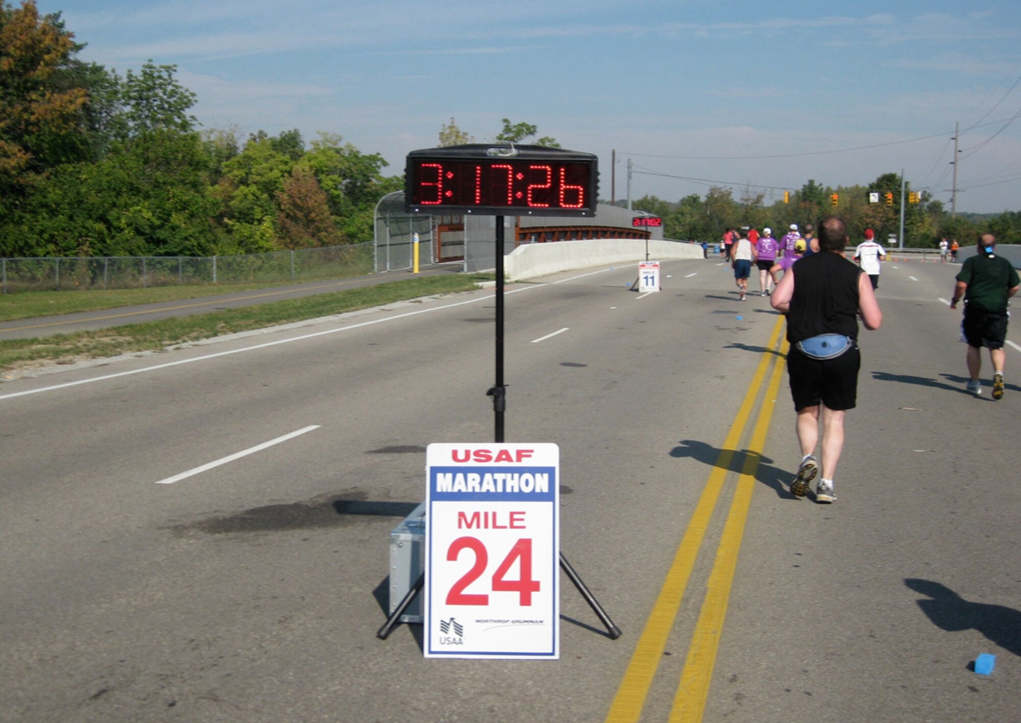 Runners pass by the 24-mile marker on their way to the finish line.

