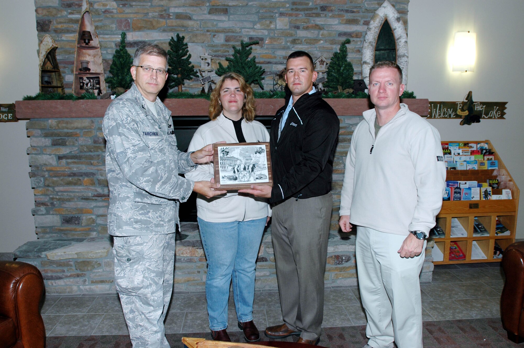 Michelle Ingraham, 934th anti terrorism officer, receives a plaque from Col. Tim Tarchick, 934th Airlift Wing commander, and a Marine contingent recognizing her support during the Republican National Convention. (Air Force Photo/Staff Sgt. Josh Nason)