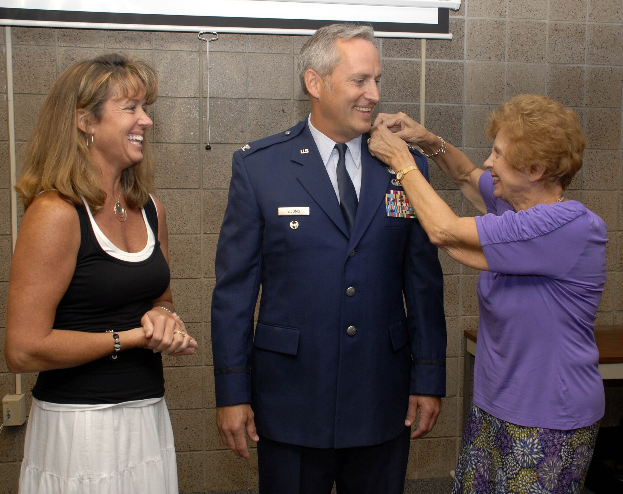 Col. Mark Vijums, 934th Airlift Wing vice commander, has his new eagles pinned on by his wife Robin and mother Aija. (Air Force Photo/Master Sgt. Paul Zadach).