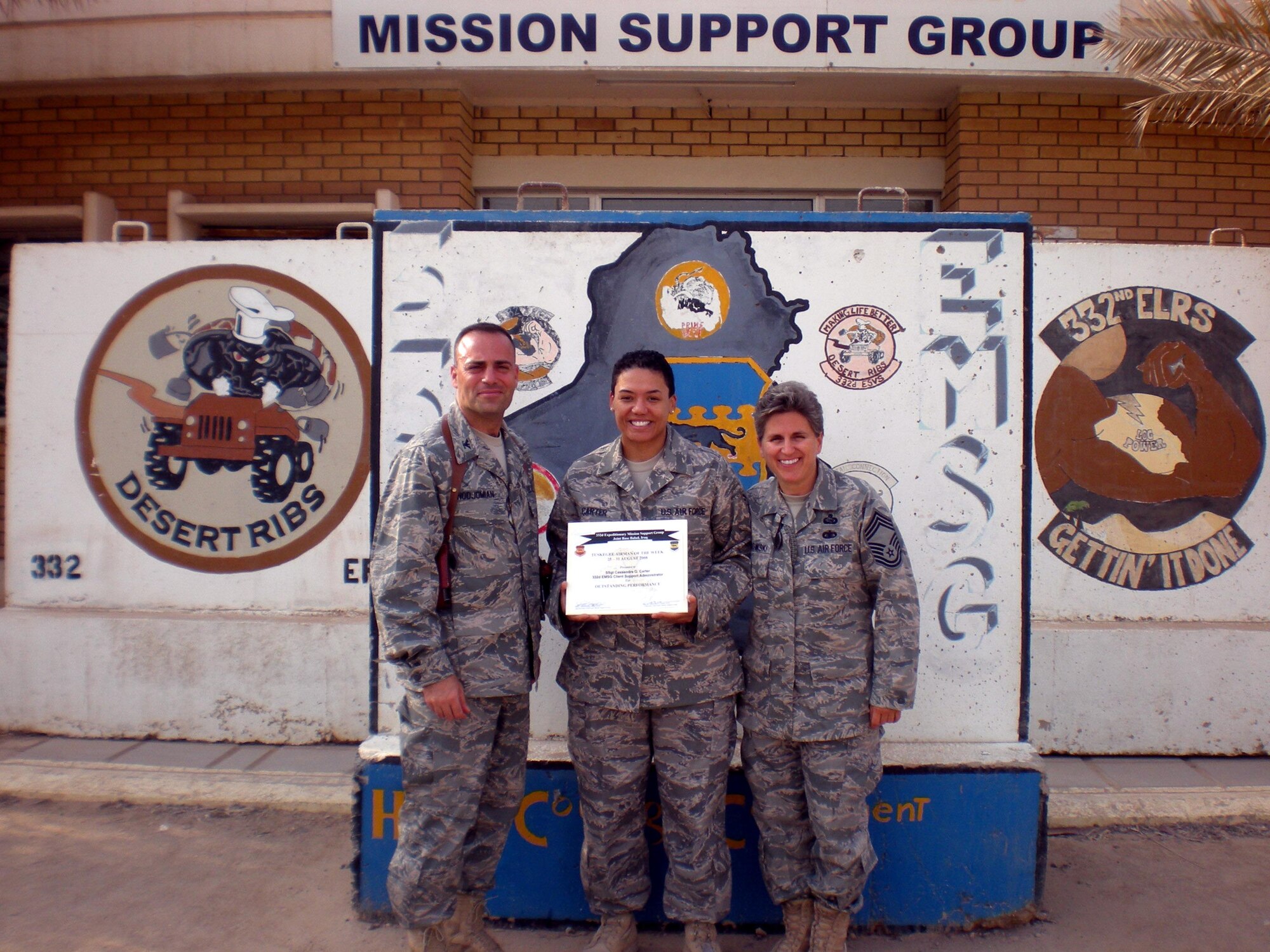 Staff Sergeant Cassandra Carter, 332nd Expeditionary Mission Support Group, Joint Base/Balad, Iraq, is presented the Tuskegee Airman of the Week award by Col. Sal Nodjomian (left) and Command Chief Master Sgt. Peri Rogowski. Sergeant Carter is assigned to the 934th Mission Support Group here.  (Courtesy photo)