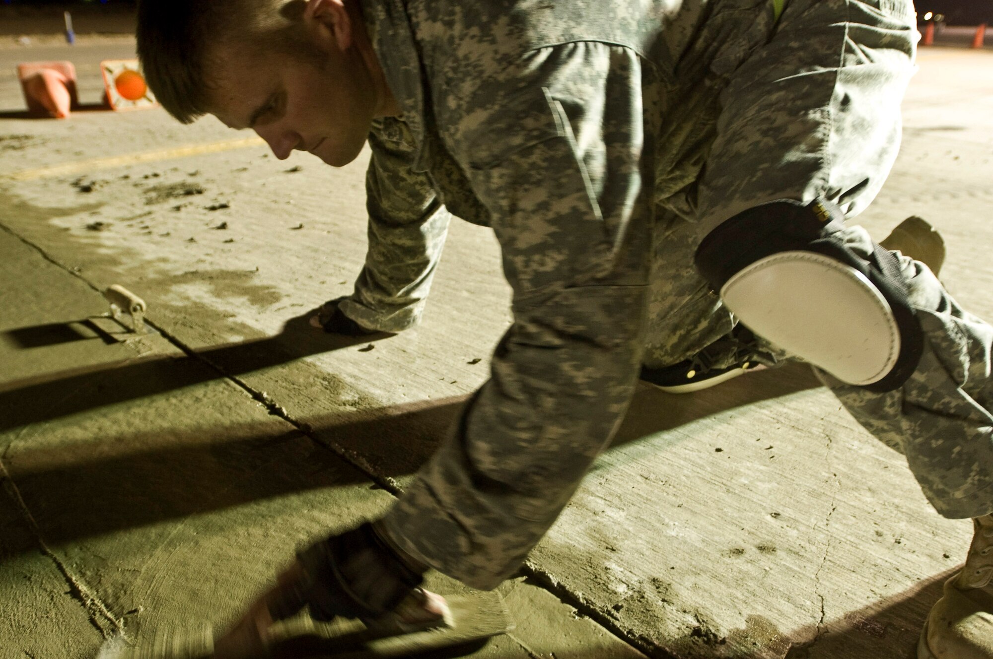 Senior Airmen Ryan Cassel flattens cement poured on the taxiway to repair cracks and potholes Sept. 22 at Ali Base, Iraq. Extreme heat, along with normal wear and tear, can damage runways, making them unsafe for aircraft. Airman Cassel, a pavements and construction equipment journeyman with the 407th Expeditionary Civil Engineer Squadron, is deployed from Pope Air Force Base, N.C. (U.S. Air Force photo/Airman 1st Class Christopher Griffin) 

