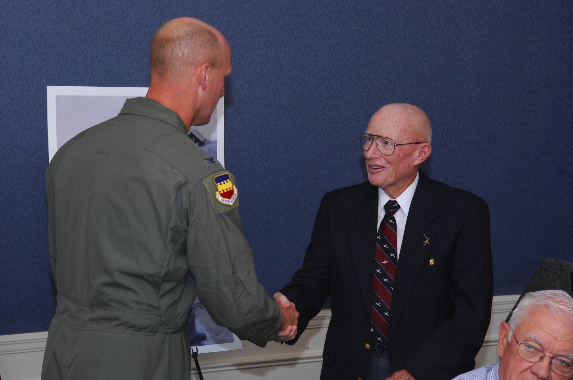 SHAW AIR FORCE BASE, S.C. -- Retired Lt. Col. Roland Richardson receives a 20th Fighter Wing coin from Col. James Post, 20th FW commander, during a luncheon at the Carolina Skies Club Sept. 26. Colonel Richardson was the last pilot to fly the RF-101 reconnaissance jet out of Shaw and was awarded the Distinguished Flying Cross for his service. An RF-101 static display was named in his honor during the luncheon. (U.S. Air Force photo/Senior Airman Matthew Davis)