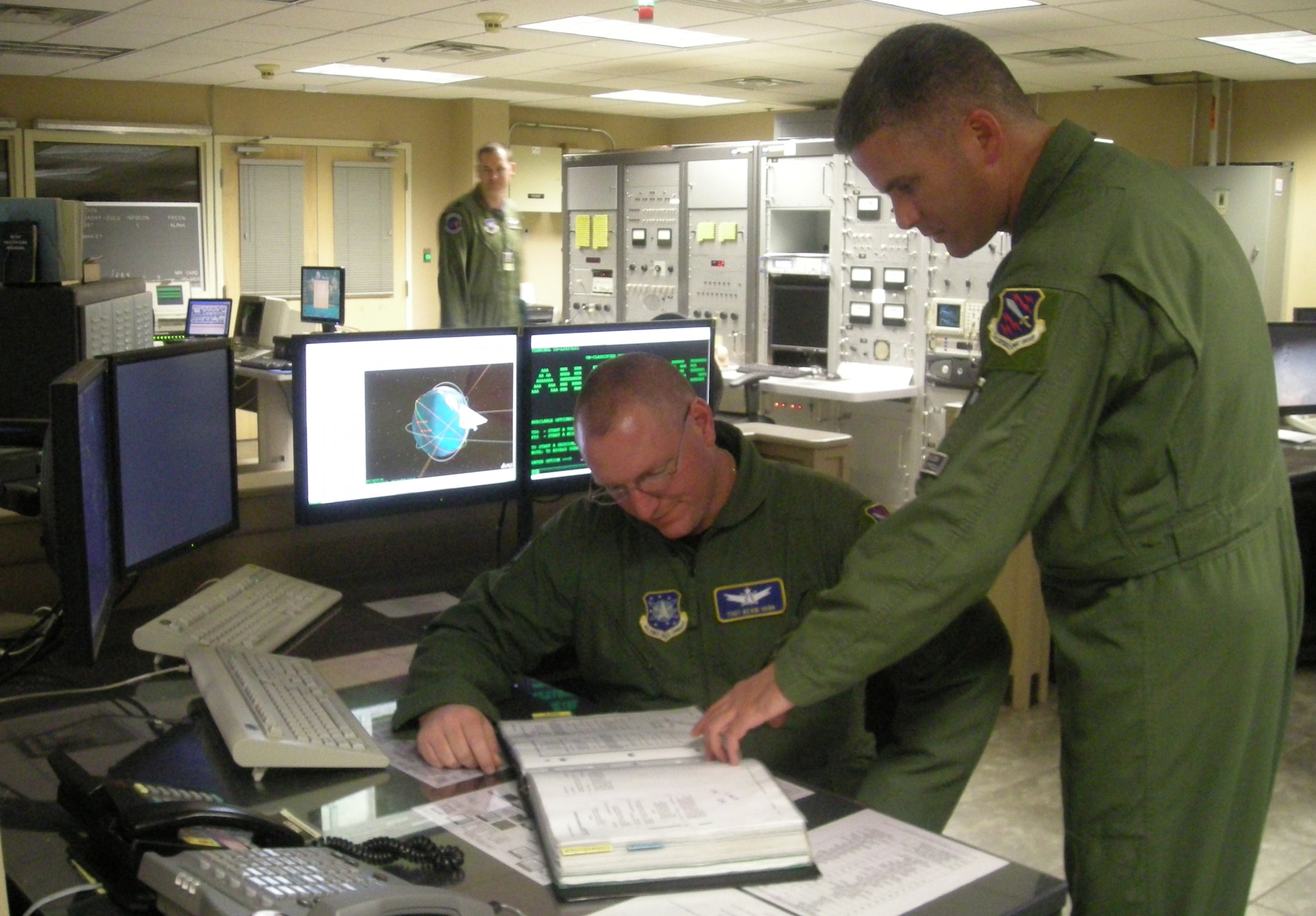 EGLIN AIR FORCE BASE, Fla. -- Tech. Sgt. Kevin Vann and Master Sgt. Dave Angermuller review a satellite tasking from Joint Space Air Operations Center. (Courtesy Photo)