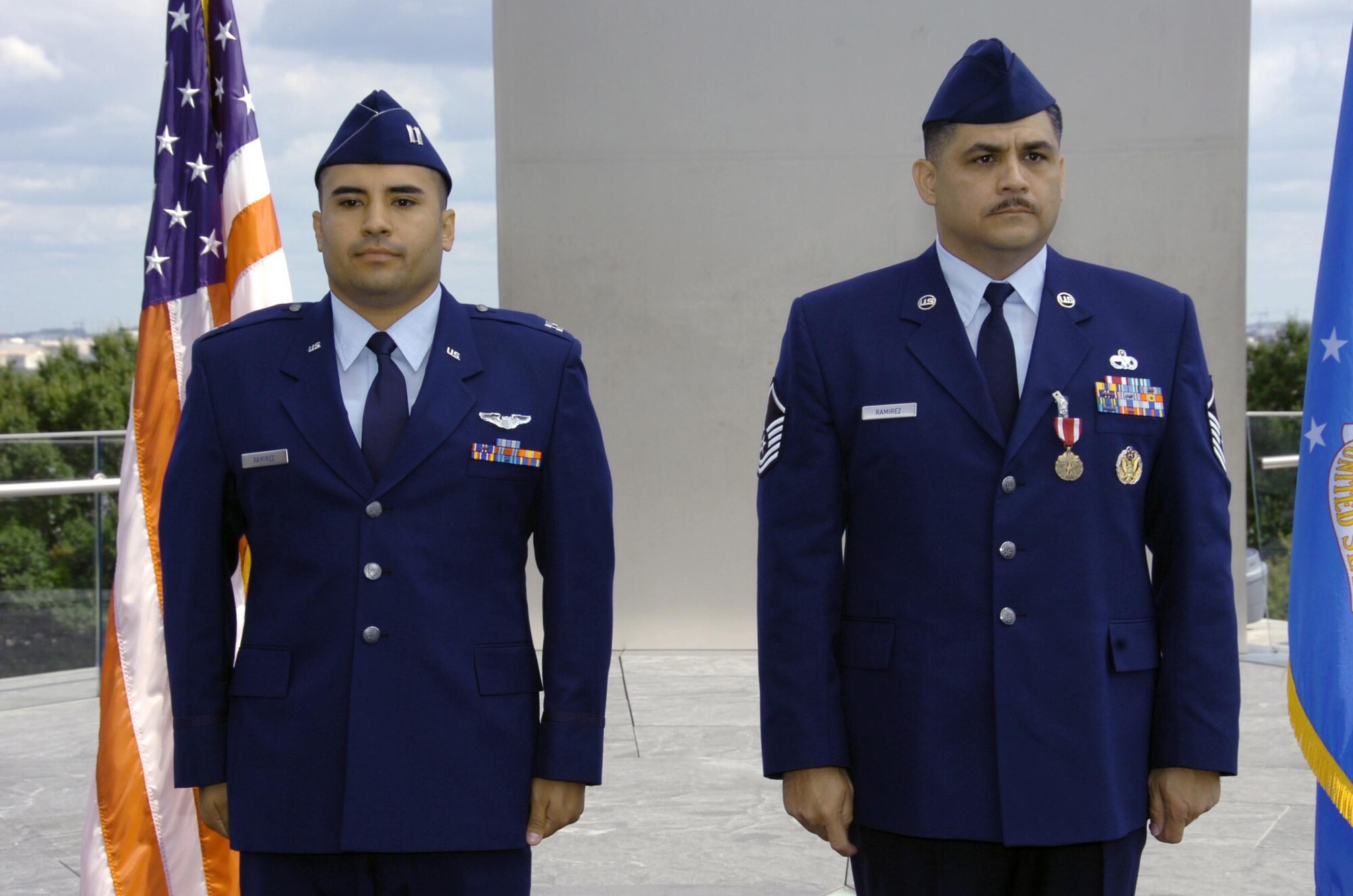 Master Sgt. Carlos Ramirez, an Air National Guard Readiness Center lead air transportation career field manager, right, stands at attention with his son, Capt. Daniel Ramirez, 1st Helicopter Squadron instructor pilot, near the Air Force Memorial honor guard Sept 19.  (USAF photo by Bobby Jones)