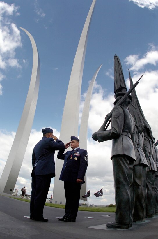 Master Sgt. Carlos Ramirez, an Air National Guard Readiness Center lead air transportation career field manager, right, renders final salute to his son, Capt. Daniel Ramirez 1st Helicopter Squadron instructor pilot, near the Air Force Memorial honor guard Sept 19.  (USAF photo by Bobby Jones)