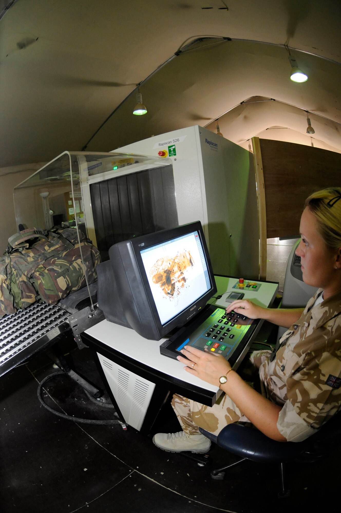 Corporal Laura Mundin, air transport security assigned to the 901st Expeditionary Air Wing, uses an X-ray security system to scan a passenger's luggage Sept. 25, 2008, at an undisclosed air base in Southwest Asia. Air transport security is responsible for locating contraband on passengers or inside their luggage that might delay passenger customs processing or threaten the safety of other passengers. Corporal Mundin, a native North Hampton, England, is deployed from Royal Air Force Uxbridge, England, supporting Operations Iraqi Freedom, Enduring Freedom and Joint Task Force-Horn of Africa. (U.S. Air Force photo by Staff Sgt. Darnell T. Cannady/Released)