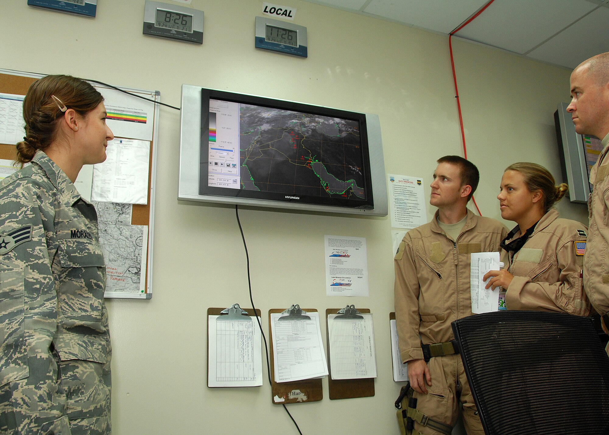 SOUTHWEST ASIA -- Senior Airman Eryn Morales, a weather forecaster assigned to the 386th Expeditionary Operations Support Squadron, briefs a C-130 Hercules aircrew on weather conditions over Iraq on Sept. 24 at an air base in Southwest Asia. The Weather flight provides accurate weather information to protect base assets including personnel, structures, equipment and the airfield from adverse weather conditions. Airman Morales is deployed from Aviano Air Base, Italy. (U.S. Air Force photo/Tech. Sgt. Raheem Moore)