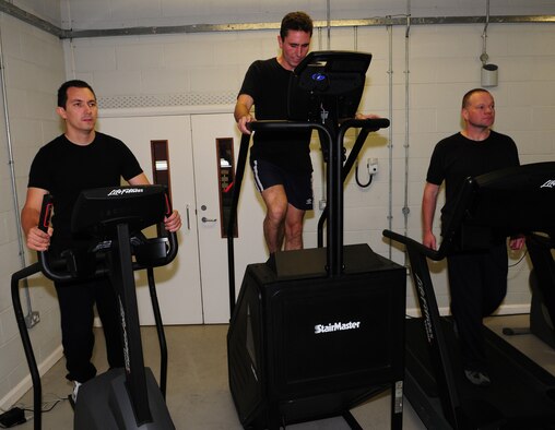 Alan Coldwell, Chris Gould and Jerry Myles, all British Defence Fire Service firefighters stationed at RAF Mildenhall, train in the fire department gym in preparation for the Three Peaks Challenge which they will undertake Oct. 2 to 3. The challenge involves climbing Ben Nevis, Scotland, Scaffel Pike, England, and Mount Snowdon, Wales, all within a total of 24 hours (including travelling between mountains). The men decided to work together, along with ex-collegue, Simon Dowling, formerly at RAF Mildenhall and now working at RAF Wattisham, to raise money for various charities they have personal involvement with. This is the first time any of the four will have attempted to climb a mountain, and as there are no mountains in the local area for them to train on, they have been working out hard in the gym and up and down the stairs of the air traffic control tower at RAF Mildenhall. (U.S. Air Force photo by Karen Abeyasekere)