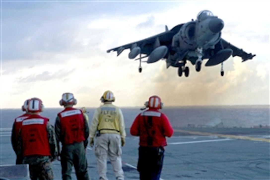Sailors and Marines watch as a Marine AV-8B Harrier aircraft lands aboard the forward-deployed amphibious assault ship USS Essex off the coast of Okinawa, Japan, Sept. 23, 2008. The aircraft is part of Marine Attack Squadron 223, 31st Marine Expeditionary Unit, which is working together with sailors of the Essex Expeditionary Strike Group during their fall deployment.
