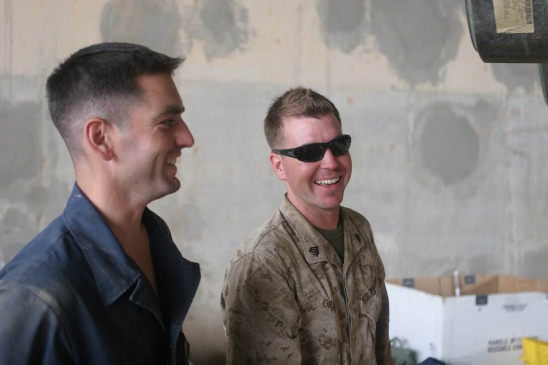 Sgt. Jonathan J. Gray (right), 28, acting platoon sergeant and tank commander with 1st Platoon, Company A, 4th Tank Battalion, Regimental Combat Team 5, talks with his head mechanic, Sgt. Joshua D. Barder, 26, also with 4th Tank Bn., at Al Asad Air Base, Iraq, Sept. 26. Gray is a reservist who opted to extend to deploy to Iraq because he found out his unit was going to be shorthanded. ::r::::n::