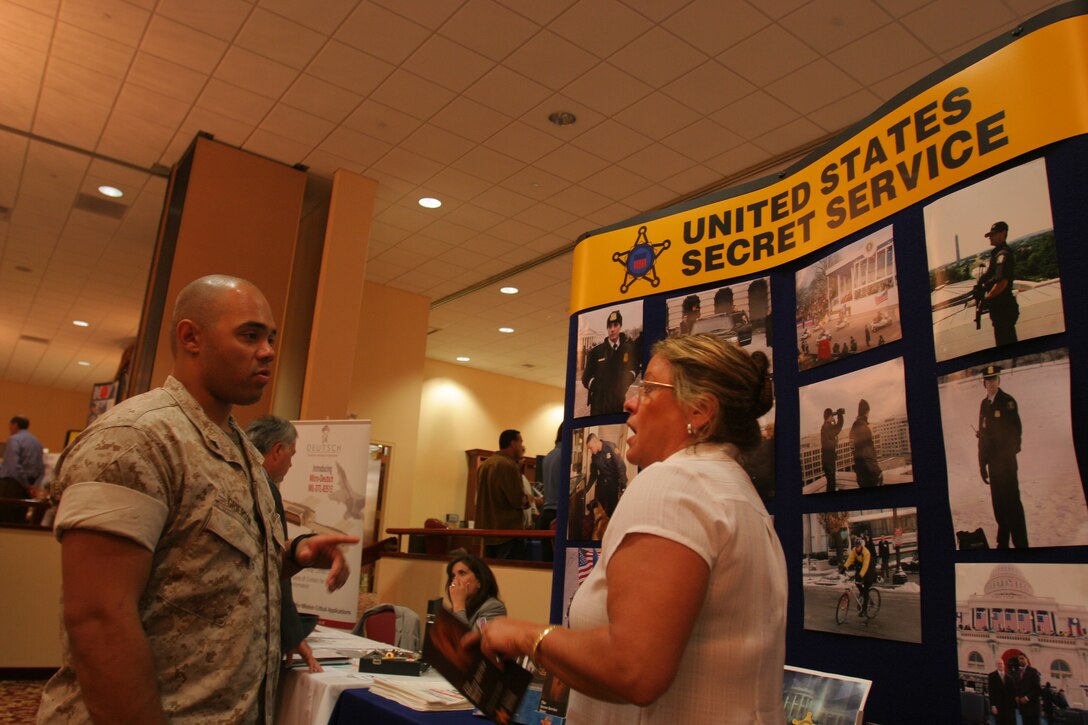 Cpl. Raphael F. Grierson Jr., air support net operator, Marine Air Support Squadron 3, discussed opportunities with Jacqueline Wasson, recruiter, personnel division, U.S.::r::::n::Secret Service, during the fall Career Fair at the South Mesa Club, Sept. 25.