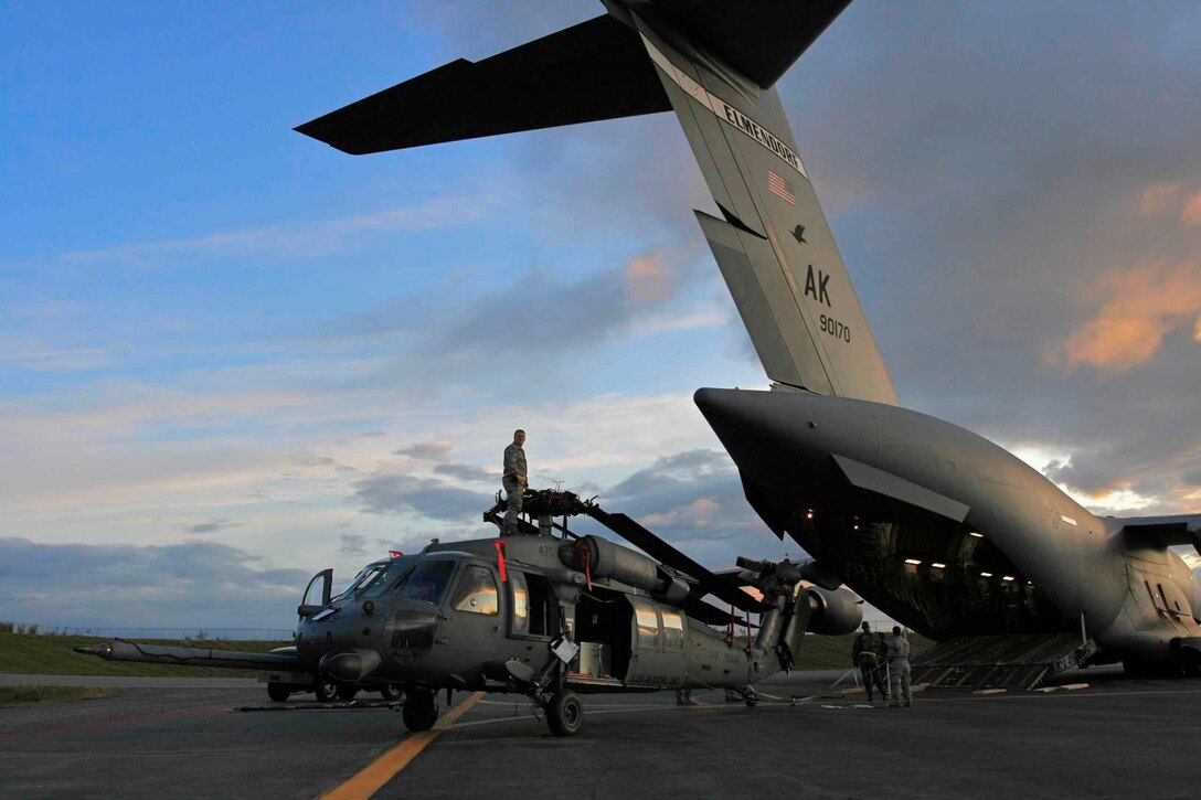 A crew from the 176th Maintenance Squadron loads an HH-60 Pave Hawk helicopter onto a waiting C-17 in the early morning of Aug. 21, 2008. The Alaska Air National Guard's 176th Wing sent two helicopters and about 30 pararescuers and aircrew members to the Gulf Coast to perform search-and-rescue operations in the aftermath of hurricanes Gustav and Ike. Alaska Air National Guard photo by TSgt Sean Mitchell.