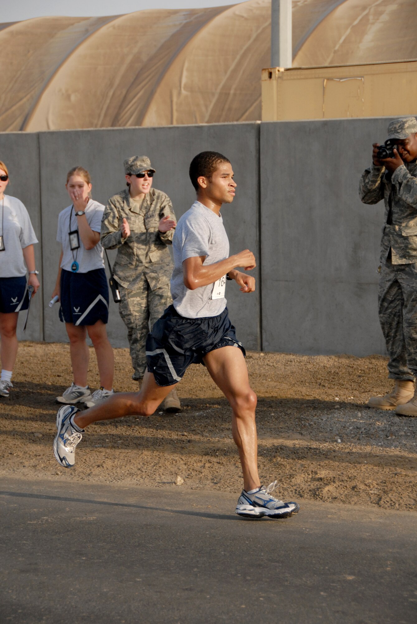 SOUTHWEST ASIA -- Mike Bowman gets cheered on from the sidelines as he finishes first place in the 13.1-mile "half-marathon" held at the 380th Air Expeditionary Wing today with a time of 1:26:10. The winner is a Boston Marathon qualifier and hopes to qualify for other named marathons as well. This event is an official extension of the U.S. Air Force Marathon that was held at Wright-Patterson Air Force Base, Ohio, Sept. 20. Extensions of the marathon allow deployed Airmen to compete as long as they are registered and the event follows official rules. Extensions must be held within 10 days of the actual marathon. (U.S. Air Force photo/Tech. Sgt. Denise Johnson)(released)