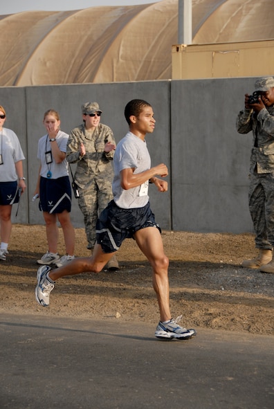 SOUTHWEST ASIA -- Mike Bowman gets cheered on from the sidelines as he finishes first place in the 13.1-mile "half-marathon" held at the 380th Air Expeditionary Wing today with a time of 1:26:10. The winner is a Boston Marathon qualifier and hopes to qualify for other named marathons as well. This event is an official extension of the U.S. Air Force Marathon that was held at Wright-Patterson Air Force Base, Ohio, Sept. 20. Extensions of the marathon allow deployed Airmen to compete as long as they are registered and the event follows official rules. Extensions must be held within 10 days of the actual marathon. (U.S. Air Force photo/Tech. Sgt. Denise Johnson)(released)