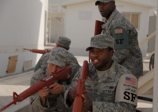 SOUTHWEST ASIA -- Airman 1st Class Patrick Richard (front), Senior Airman Sean Malec (left), and Airman 1st Class Robert Sosa (back), all fire team members for the 380th Expeditionary Security Forces Squadron; train on tactics and movements with Staff Sgt. Tyrone Jackson (standing), fire team leader. The team is practicing movement techniques in built-up environments. The security forces Airmen encountered hostile and non-hostile scenarios and were evaluated on their reactions. (U.S. Air Force photo/Tech. Sgt. Denise Johnson)(released)