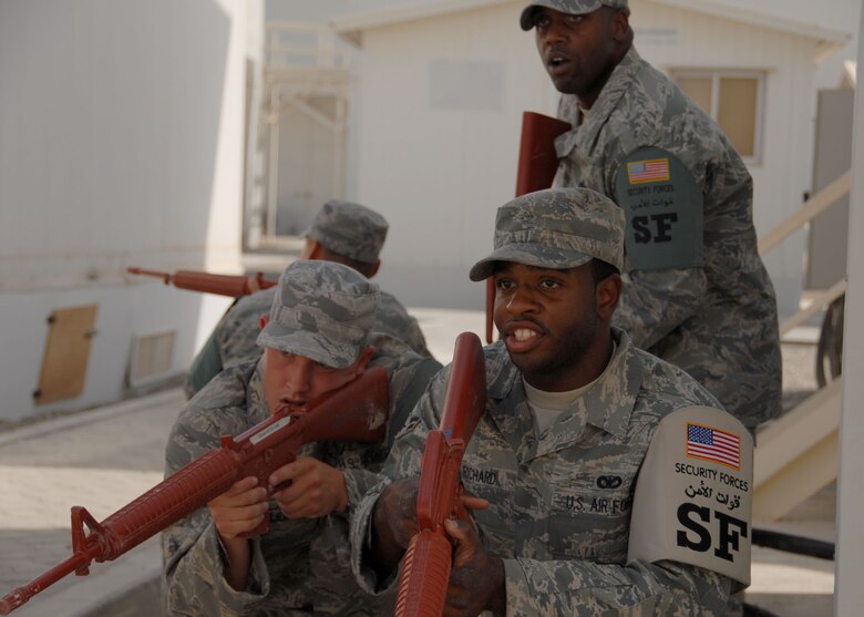 SOUTHWEST ASIA -- Airman 1st Class Patrick Richard (front), Senior Airman Sean Malec (left), and Airman 1st Class Robert Sosa (back), all fire team members for the 380th Expeditionary Security Forces Squadron; train on tactics and movements with Staff Sgt. Tyrone Jackson (standing), fire team leader. The team is practicing movement techniques in built-up environments. The security forces Airmen encountered hostile and non-hostile scenarios and were evaluated on their reactions. (U.S. Air Force photo/Tech. Sgt. Denise Johnson)(released)