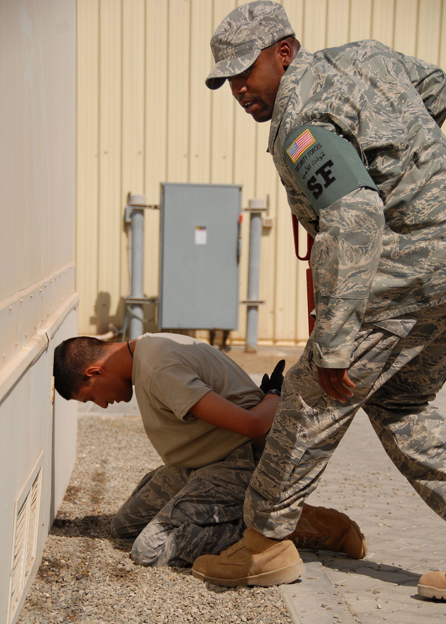 SOUTHWEST ASIA -- Staff Sgt. Tyrone Jackson, 380th Expeditionary Security Forces Squadron fire team leader, detains Staff Sgt. Luis Ramos, 38oth ESFS trainer, during fire-team movement training. This portion of the training was designed to test the reactions of security forces members when they encounter non-hostile individuals in the urban battlefield. (U.S. Air Force photo/Tech. Sgt. Denise Johnson)(released)