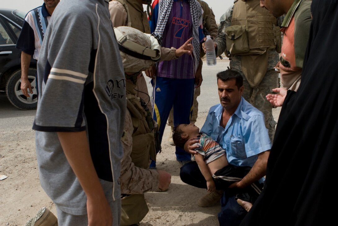 KARMAH, Iraq-An Iraqi man holds his drowning child in Karmah, Iraq, Sept. 28. Navy Chief Roger Buck, a 34-year-old battalion medical chief from Niceville, Fla., with Task Force 1st Battalion, 3rd Marine Regiment, Regimental Combat Team 1, saw the limp child cradled in his fatherâ??s arms and immediately began administering CPR on the drown victim, saving his life. (U.S. Marine Corps photo by Lance Cpl. Geoffrey T. Campbell/Released)