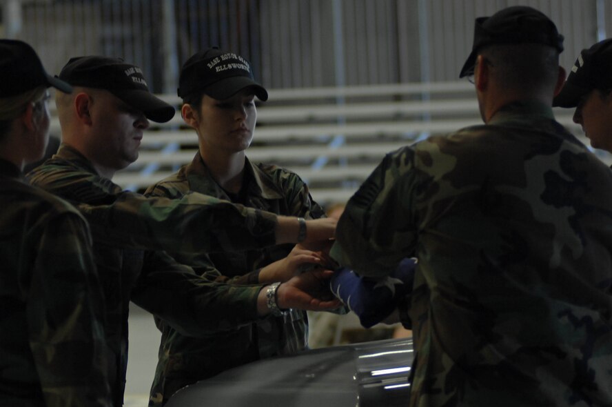 Ellsworth Air Force Base Honor Guard fold the American flag in a simulated funeral ceremony here, Sept. 25. The simulation served as a means of educating the public about the mission of the honor guard. (U.S. Air Force photo by Airman Corey Hook)


