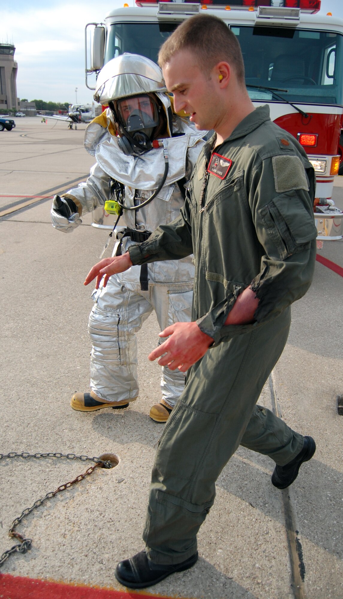 LAUGHLIN AIR FORCE BASE, Texas – A firefighter from the 47th Installation Support Squadron assists a simulated burn victim in finding his way to a medical treatment area during an exercise on the flight line here Sept. 24.  The exercise involved several victims made up with detailed burns and other wounds, called moulage, which assists responders in identifying simulated injuries.  (U.S. Air Force photo by Staff Sgt Austin M. May)