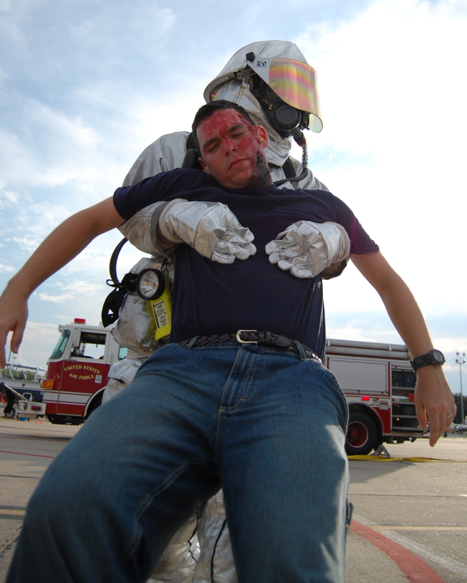 LAUGHLIN AIR FORCE BASE, Texas – A firefighter from the 47th Installation Support Squadron drags the limp body of a simulated explosion victim during an exercise on the flight line here Sept. 24.  The exercise involved several victims made up with detailed burns and other wounds, called moulage, which assists responders in identifying simulated injuries.  (U.S. Air Force photo by Staff Sgt Austin M. May)