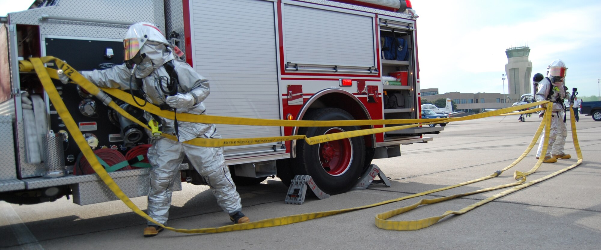 LAUGHLIN AIR FORCE BASE, Texas – Firefighters from the 47th Installation Support Squadron pull hoses from a fire truck to battle a simulated blaze during an exercise here Sept. 24.  Laughlin routinely practices responding to various emergency situations to ensure base personnel are prepared to handle any situation.  (U.S. Air Force photo by Staff Sgt Austin M. May)