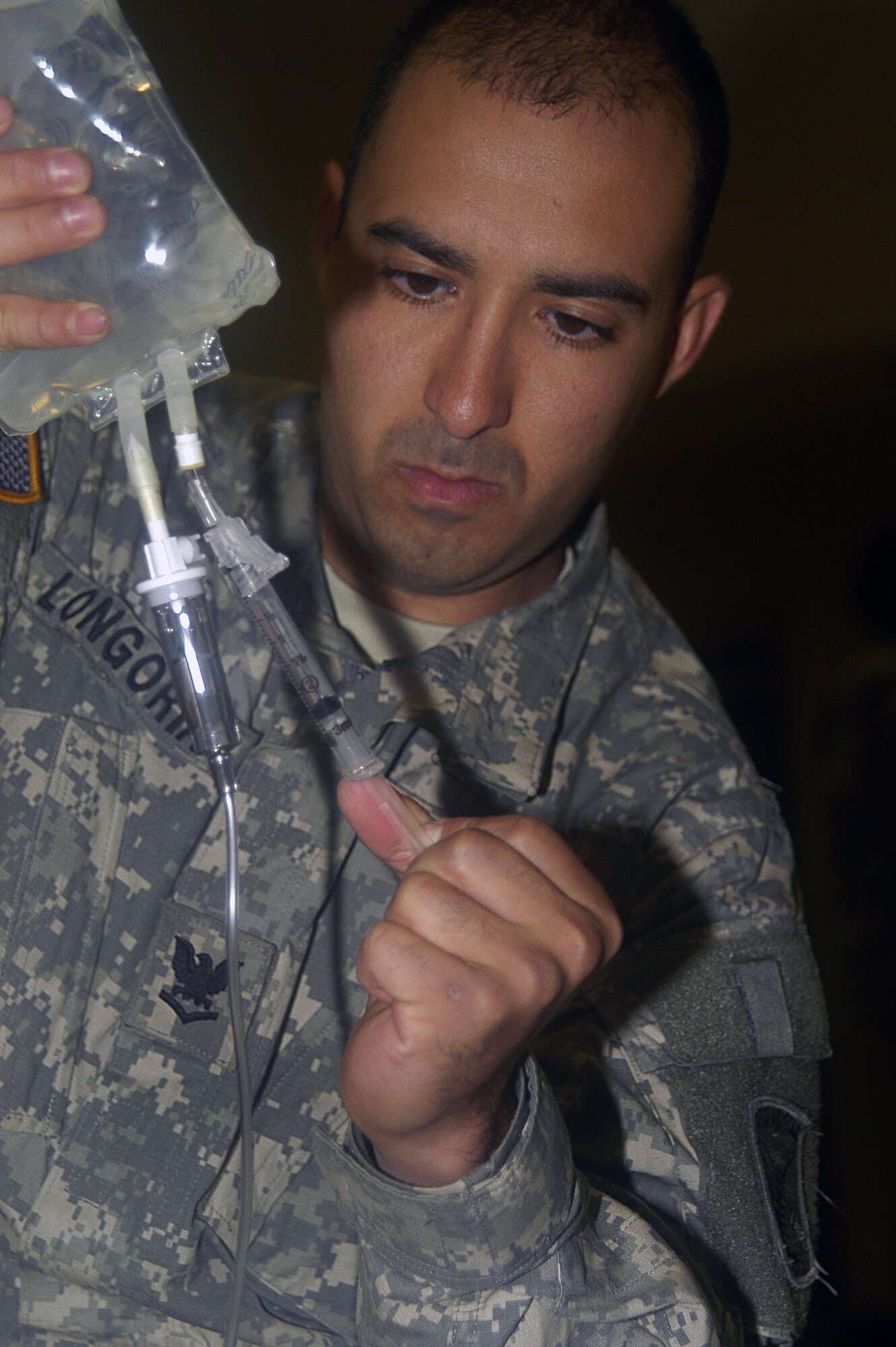Navy Petty Officer 3rd Class Armondo Longoria flushes out an intravenus line in preparation for administering an IV during Combat Lifesaver Skills training Sept. 24 at Fort Bragg, N.C. Combat Lifesaving Skills training is part of the Combat Skills Training Airmen, Sailors and Soldiers are receiving prior to their Provincial Reconstruction Teams' deployments to Afghanistan. Petty Officer Longoria is assigned to the Paktika PRT, one of 12 teams deploying to Afghanistan in November. (U.S. Air Force photo/Master Sgt. Eric M. Grill) 