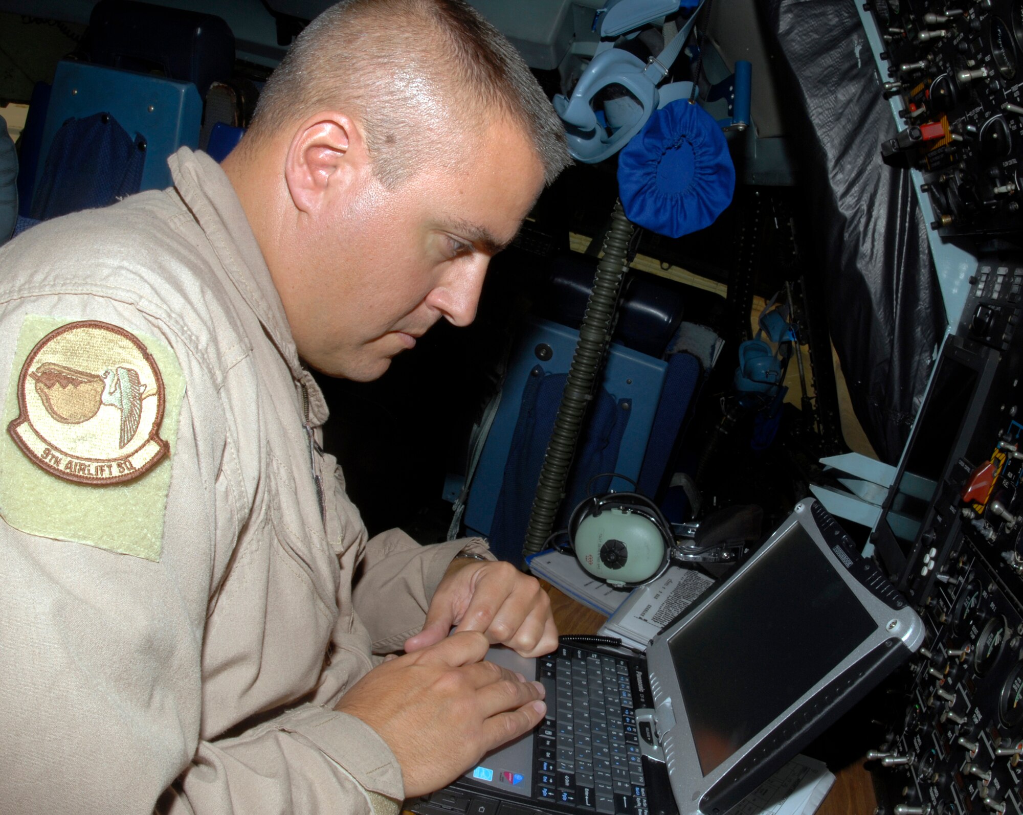 Tech. Sgt. Jeff Seren computes takeoff and landing data Sept. 26 in the cockpit of a C-5 Galaxy cargo aircraft at Joint Base Balad, Iraq. The C-5 is assigned to the 436th Airlift Wing at Dover Air Force Base, Del. Sergeant Seren is a flight engineer assigned to the 9th Airlift Squadron at Dover AFB. (U.S. Air Force photo/Tech. Sgt. Erik Gudmundson)