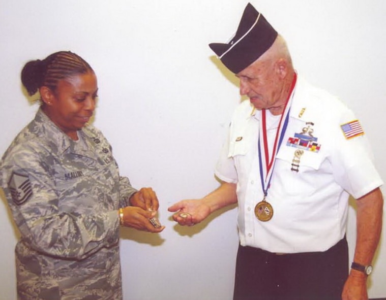 MOODY AIR FORCE BASE, Ga. -- Master Sgt. Harriet Mallory, 23rd Force Support Squadron career advisor, presents Hank "Sarge" McQuinn two coins here Sept. 12. One coin was from the Moody Top Three and the other as a memento from Moody's 2008 Master Sergeant Select inductees. (Courtesy photo)