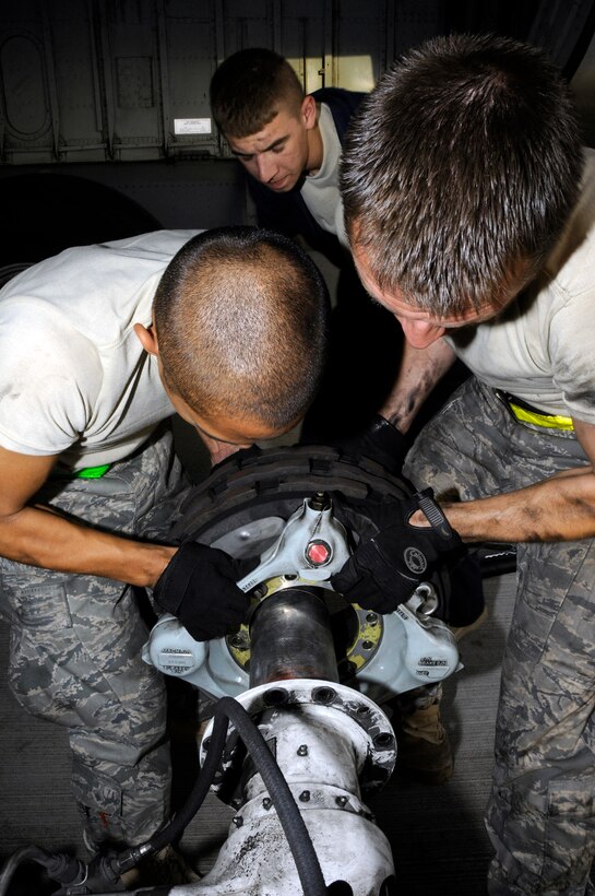 Tech. Sgt. Chris Reiter and Airman 1st Class James Giesick lift a new brake unit onto a KC-135 Stratotanker landing gear axle as Airman 1st Class Ryan McMillen assists Sept. 28 at an air base in Southwest Asia. The brake set had to be replaced when a crack in the heat shield was detected during a post-flight inspection. Sergeant Reiter, a native of Farmington, N.M., is deployed from Fairchild Air Force Base, Wash. Airman McMillen is from Warsaw, Ill., and deployed from McConnell AFB, Kan. Airman Giesick, originally from San Diego, is deployed from Grand Forks AFB, N.D. All are assigned to the 379th Expeditionary Aircraft Maintenance Squadron. (U.S. Air Force photo/Tech. Sgt. Michael Boquette) 