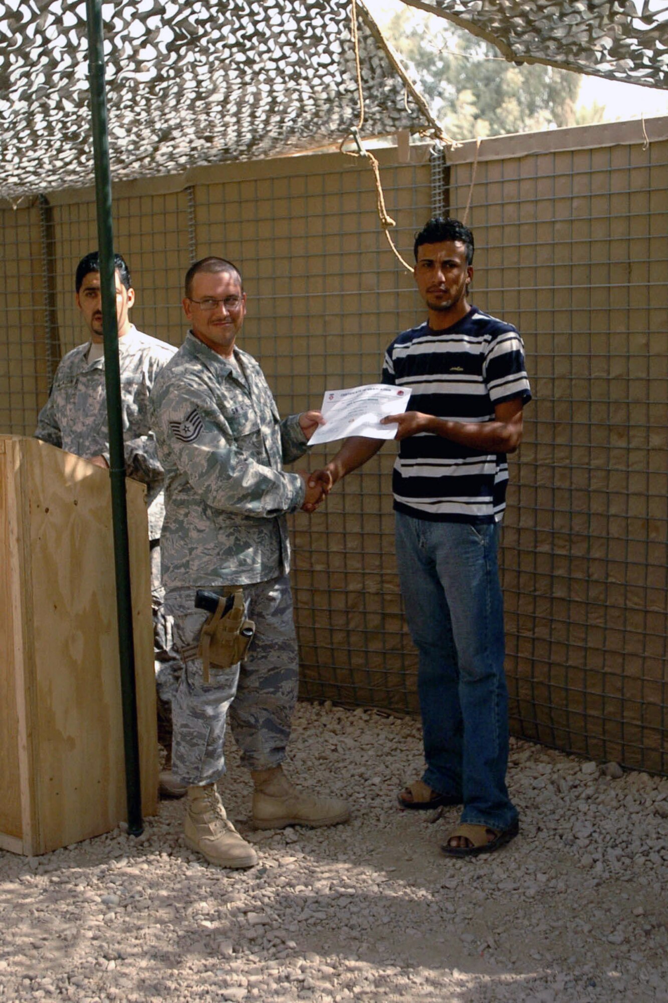 A student receives his diploma during the final Village of Hope graduation ceremony at Patrol Base Stone, Iraq, Sept. 25. (U.S. Army photo/Pfc. Christopher McKenna)
