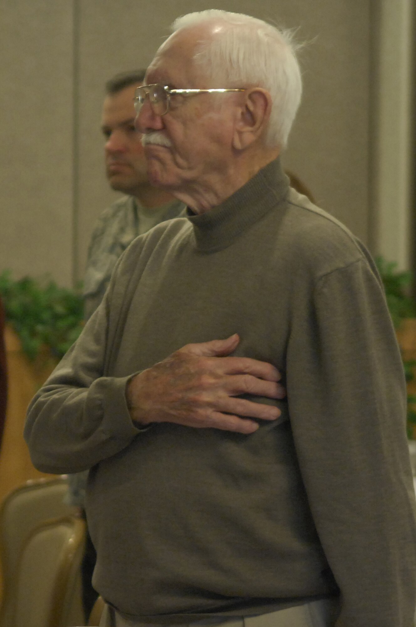 MINOT AIR FORCE BASE, N.D. --Don Fifer pays tribute during the playing of the National Anthem at a POW/MIA Recognition Day luncheon held at the Jimmy Doolittle Center here Sept. 25. Mr. Fifer was a POW during World War II. (U.S. Air Force photo by Senior Airman Joe Rivera)