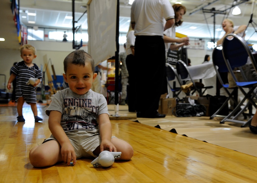 MOODY AIR FORCE BASE, Ga. -- Connor Kenney, 3, son of Staff Sgt. Matthew Kenney, 23rd Civil Engineer Squadron firefighter, plays with toys on the floor while his mother runs a booth at the Moody Fun Fair here Sep. 26. Many local organizations set up booths to give information to the Airmen of Moody AFB. (U.S. Air Force photo by Senior Airman Brittany Barker)