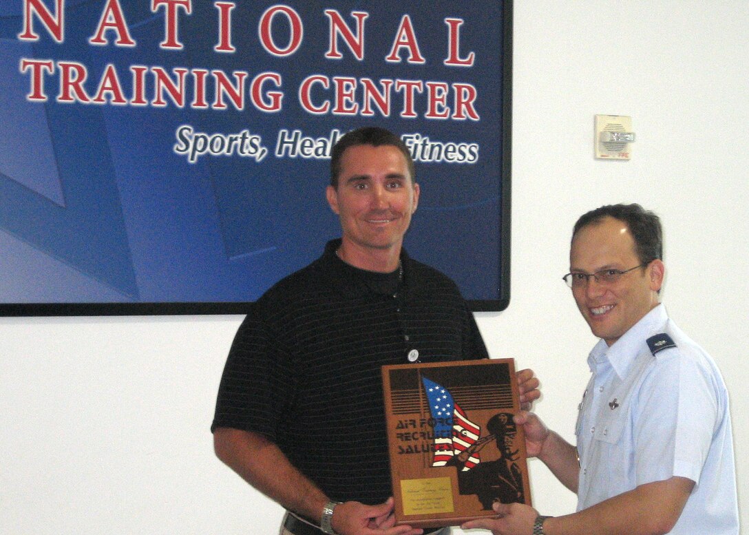 Lt. Col. Jeffrey J. Waters, 333rd Recruiting Squadron commander, presents an Air Force Recruiting Salutes plaque to the National Training Center in Orlando, Fla., Sept. 25. The prestigious award is given to deserving individuals or businesses who have contributed to the success of the Air Force recruiting mission. The National Training Center assisted the local recruiting flight, directed by Master Sgt. Carmelo Vega, to conduct more than 30 Physical Ability and Stamina Tests for special operations applicants this year at no cost. The center’s contribution saved the 333rd RCS more than $500 in its mission of recruiting the right people for the right job. As Air Force recruiters work to find the right people for special operations jobs, the support of institutions such as the National Training Center is vital to our nation and winning the war on global terrorism. (U.S. Air Force photo)