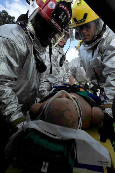 MOODY AIR FORCE BASE, Ga. -- Staff Sgt. Darren Gould and Staff Sgt. Anthony Reynolds, 23rd Civil Engineer Squadron fire protection crew chiefs, and Airman 1st Class Hunter Green, 23rd Civil Engineer Squadron firefighter, remove Rescue Randy from a vehicle during training here Sept. 11. The firefighters are taught to maintain C-spine immobilization when extracting a victim. (U.S. Air Force photo by Senior Airman Elizabeth Rissmiller)
