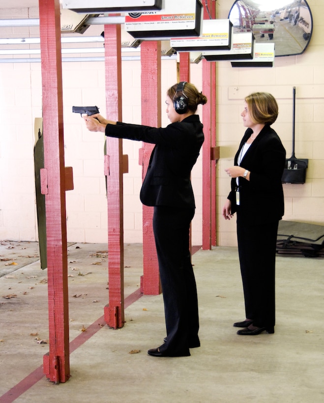 Rosario Dawson prepares to fire a M11 pistol under the watchful eye of Special Agent Rachel Ouellette at the firing range at Andrews Air Force Base, Md. Ms. Dawson was at the base researching her role as a Special Agent with the Air Force Office of Special Investigations in the movie 'Eagle Eye.' (U.S. Air Force photo/Mike Hastings)