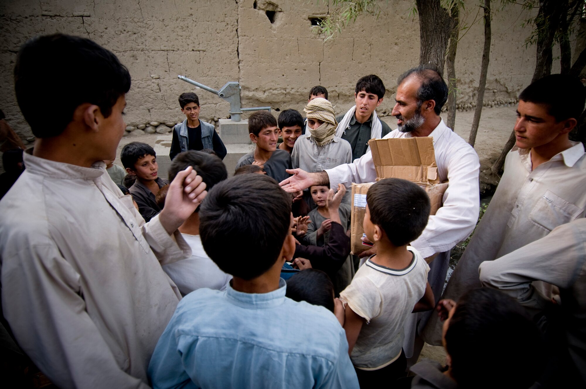 Afghanistan -- A village elder distributes crayons and toys for the children.   (U.S. Air Force photo by Staff Sgt. Samuel Morse/Released)