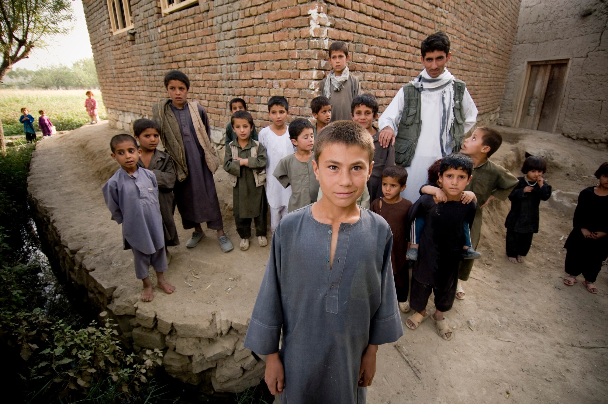 Afghanistan -- The prospect of a group photo brings out many Afghan children in village.  The villagers are happy to see Americans and welcome photos. (U.S. Air Force photo by Staff Sgt. Samuel Morse/Released)