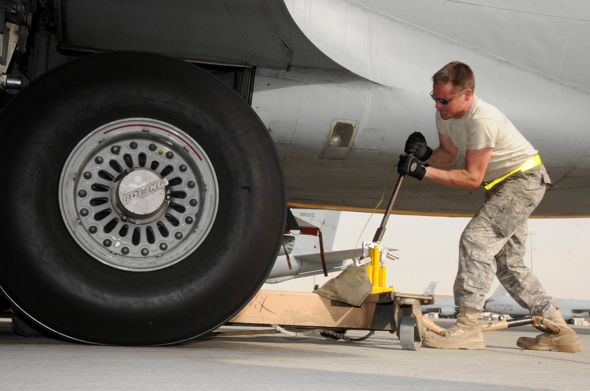 Tech. Sgt. Chris Reiter, 379th Expeditionary Aircraft Maintenance Squadron, 340th Aircraft Maintenance Unit, cranks on a jack lifting over 300,000 pounds of KC-135 aircraft and fuel Sept. 28, 2008, at an undisclosed air base in Southwest Asia.  The tire needs to be removed and the brake unit replaced after a crack in the heat shield was detected during a post-flight inspection.  Sergeant Reiter, a native of Farmington, N.M., is deployed from Fairchild Air Force Base, Wash.  Airman Giesick is from San Diego, Calif., and is deployed from Grand Forks AFB, N.D., and Airman McMillen, originally from Warsaw, Ill., is deployed from McConnell AFB, Kan.  All are deployed here supporting Operations Iraqi and Enduring Freedom and Joint Task Force-Horn of Africa.  (U.S. Air Force photo by Tech. Sgt. Michael Boquette/Released)
