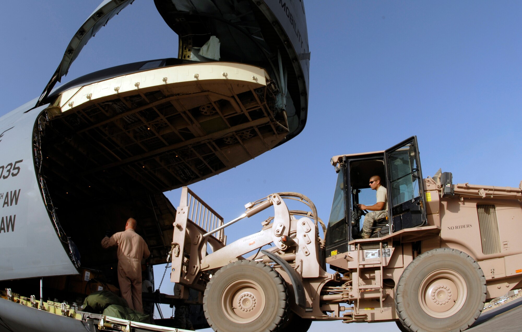 Staff Sgt. Jeffrey Szymanski (right) loads a jet engine aboard a C-5 Galaxy at Joint Base Balad, Iraq, Sept. 26. The C-5 is assigned to the 436th Airlift Wing at Dover Air Force Base, Del. C-5s are among the largest aircraft in the world, delivering large amounts of supply goods to units throughout the U.S. Central Command area of responsibility. Szymanski, an air transportation journeyman with the 332nd Expeditionary Logistics Readiness Squadron, is deployed from Westover Air Reserve Base, Mass. (U.S. Air Force photo/Tech. Sgt. Erik Gudmundson)