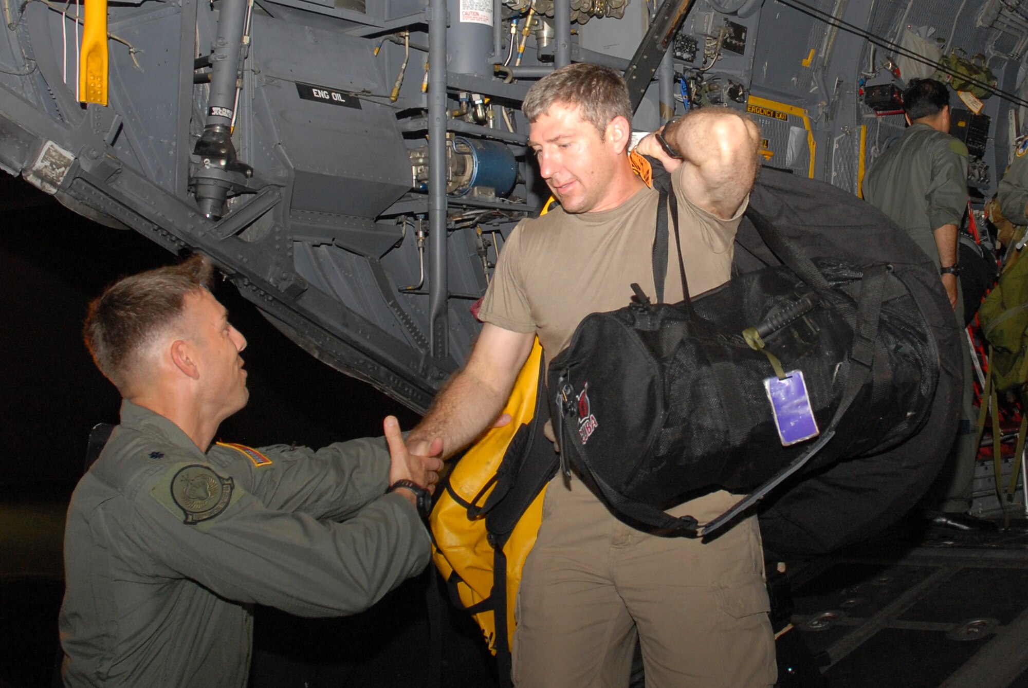 Lt. Col. Todd Woodrick, commander of the 320th Special Tactic Squadron, greets Senior Master Sgt. Thomas Rich of the 31st Rescue Squadron, as he disembarks an MC-130 at Kadena Air Base Sept. 28, 2008. Pararescuemen from the 31st RQS and members of the 320th STS left Friday afternoon aboard an MC-130 flown by the 1st Special Operations Squadron to provide medical assistance to two injured mariners aboard a Panamanian freighter 750 nautical miles north of Saipan. (U.S. Air Force photo by Staff Sgt. Chrissy Best)
