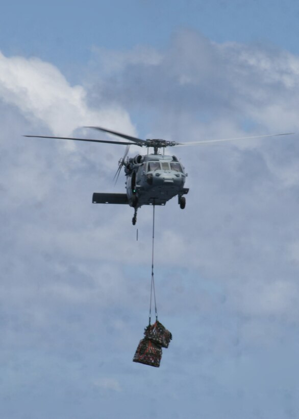 ABOARD USS PELELIU (LHA-5), (Sept. 29, 2008)- A MH-60S Seahawk helicopter flies with supplies to the flight deck of USS Peleliu during a vertical replenishment, Sept. 29. Vertical replenishments are designed to resupply a Peleliu using helicopters to transport supplies from one ship to another.::r::::n::The Camp Pendleton, Calif., based 15th MEU is embarked aboard USS Peleliu and is comprised of approximately 2,200 Marines and Sailors and is a forward deployed force in readiness capable of conducting numerous operations, such as Non-Combatant Evacuation Operations, Humanitarian Assistance Operations and range of amphibious missions.  The MEU is currently deployed aboard USS Peleliu (LHA-5), USS Dubuque (LPD-8) and USS Pearl Harbor (LSD-52).   (Official USMC photo by Cpl Stephen Holt)::r::::n::