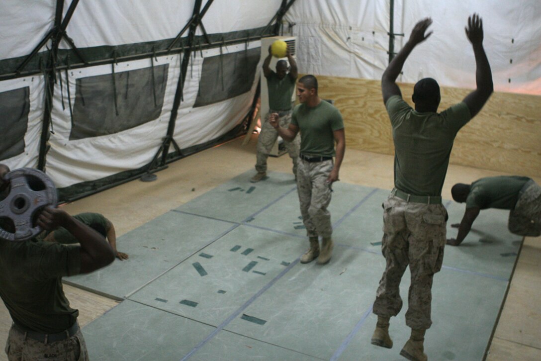 Cpl. Trevor Ryan (center), a small arms repairer/technician with Task Force 2nd Battalion, 2nd Marines, Regimental Combat Team 5, shouts, "You'll get out of this, what you put into it," as Marines struggle through an array of exercises during a Marine Corps Martial Arts Program class at Combat Outpost Rawah, Iraq Sept, 30. Ryan has graduated 50 service members in different belt levels of the MCMAP during the first five months of his current deployment.