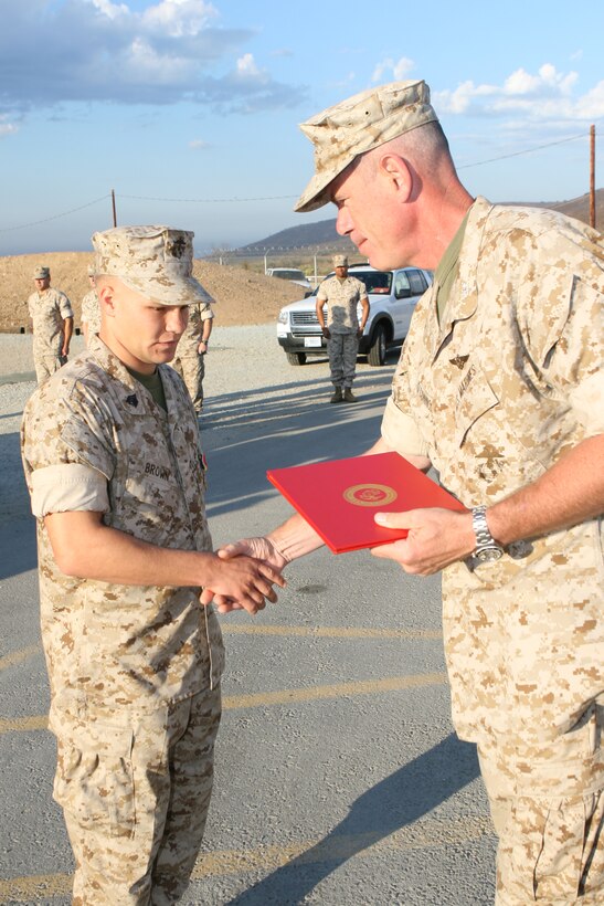 Col. Christopher E. O'Connor, the commanding officer of Marine Corps Station Miramar presents Sgt. Jullian R. Brown, a marksmanship coach with the Carlos Hathcock Range Complex, the Navy and Marine Corps Medal during an awards ceremony at the range complex, Sept. 29. The Custer S.D. native was awarded for his life-saving actions of Iraqi civilians while deployed to Husaybah, Iraq, in Nov. 2005. (Official Marine Corps photo by Lance Cpl. Christopher O'Quin)