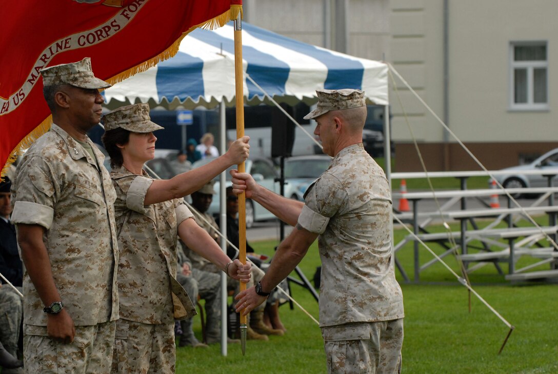 Brig. Gen. Tracy Garrett, commander of Marine Forces Europe (MFE), hands over the organizational colors to Sgt. Maj. Joseph Leshinsky, MFE sergeant major, during a change-of-command ceremony here Sept. 30.Brig. Gen. Garrett assumed command from Maj. Gen. Cornell A. Wilson Jr., whose next assignment is as the deputy commander of U.S. Marine Corps Forces Command.