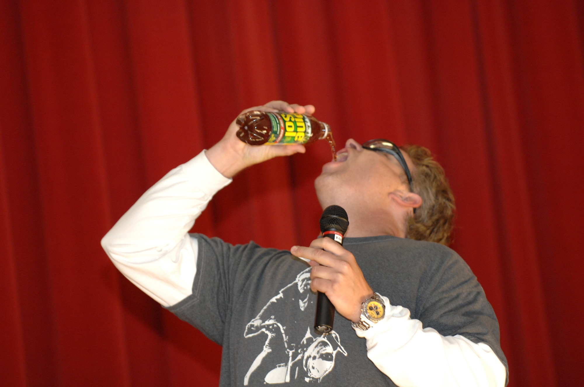 BOTTOMS-UP: Jeff Hodgson, 452 MSG, simulates drinking a bottle of household cleaner as part of his comedy act. (U.S. Air Force photo)